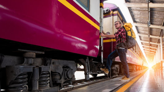 Traveler with a backpack boarding a train at an urban railway platform