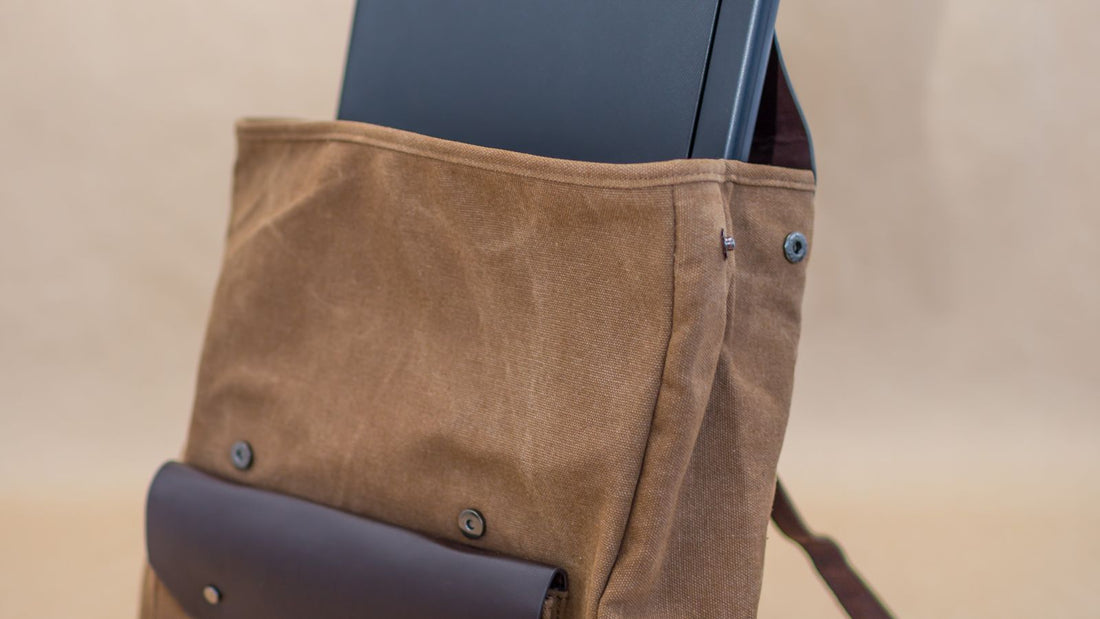 Person placing a laptop into a backpack's padded compartment