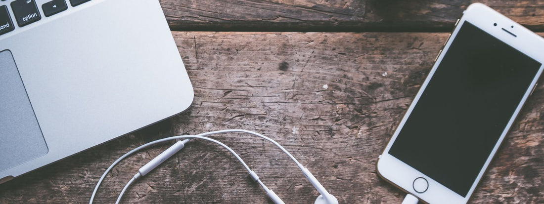 Laptop, phone and tech accessories arranged on a table