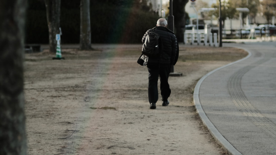 Person walking down a city street wearing a backpack while commuting