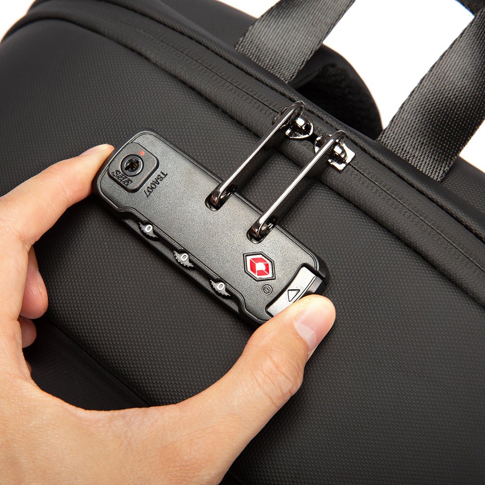 Close-up of hand using TSA-approved combination lock on black anti-theft backpack for secure zippers.