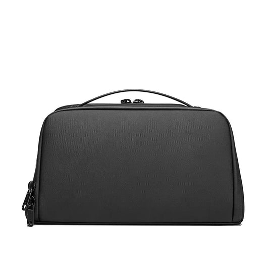Front view of black BANGE BG-22196 toiletry bag with minimalist design, smooth exterior, and top carry handle