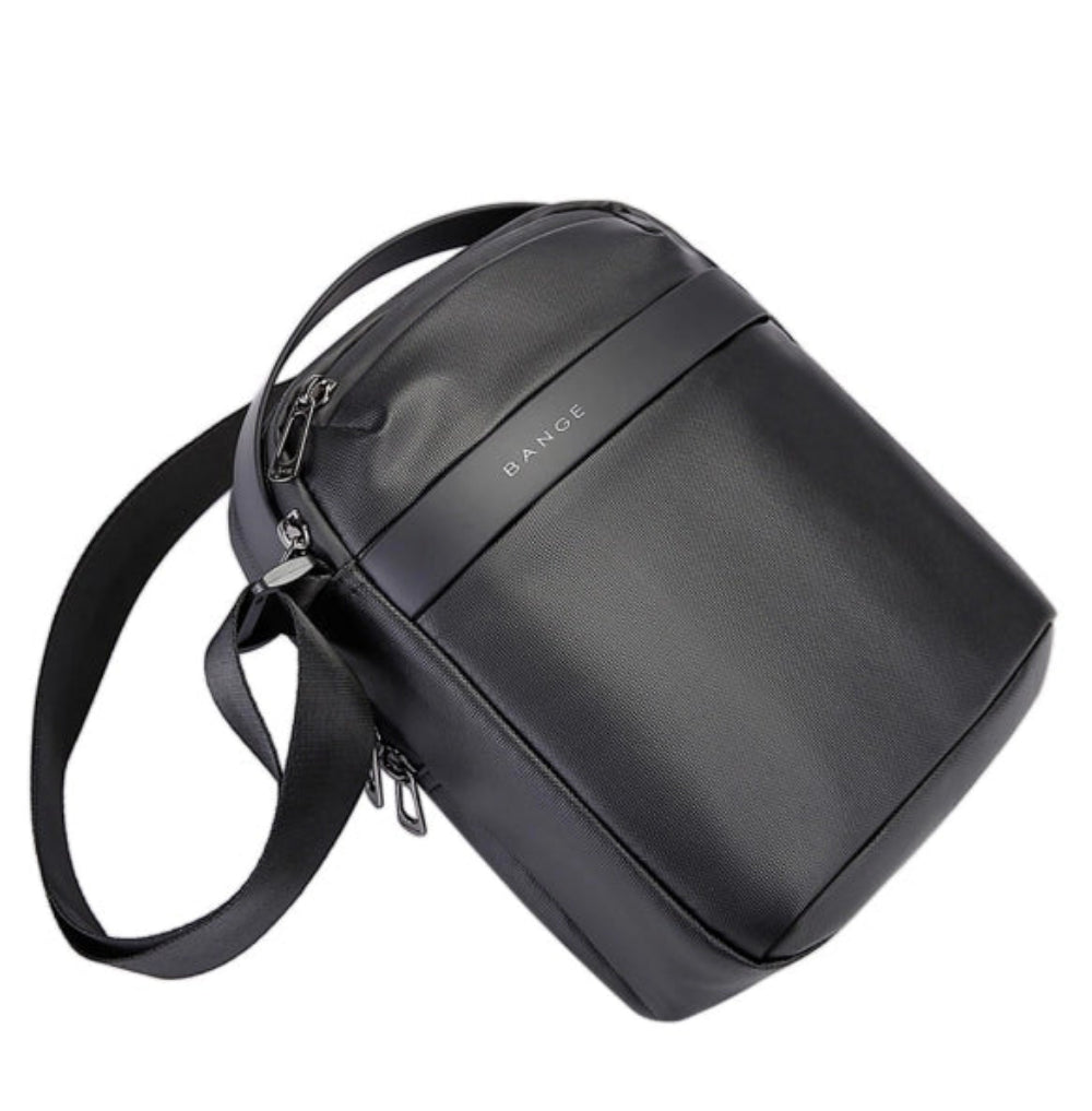 Angled view of the BANGE BG-2876 anti-theft crossbody shoulder bag showing its slim rectangular shape, top handle, adjustable shoulder strap, and minimalist BANGE branding on a white background