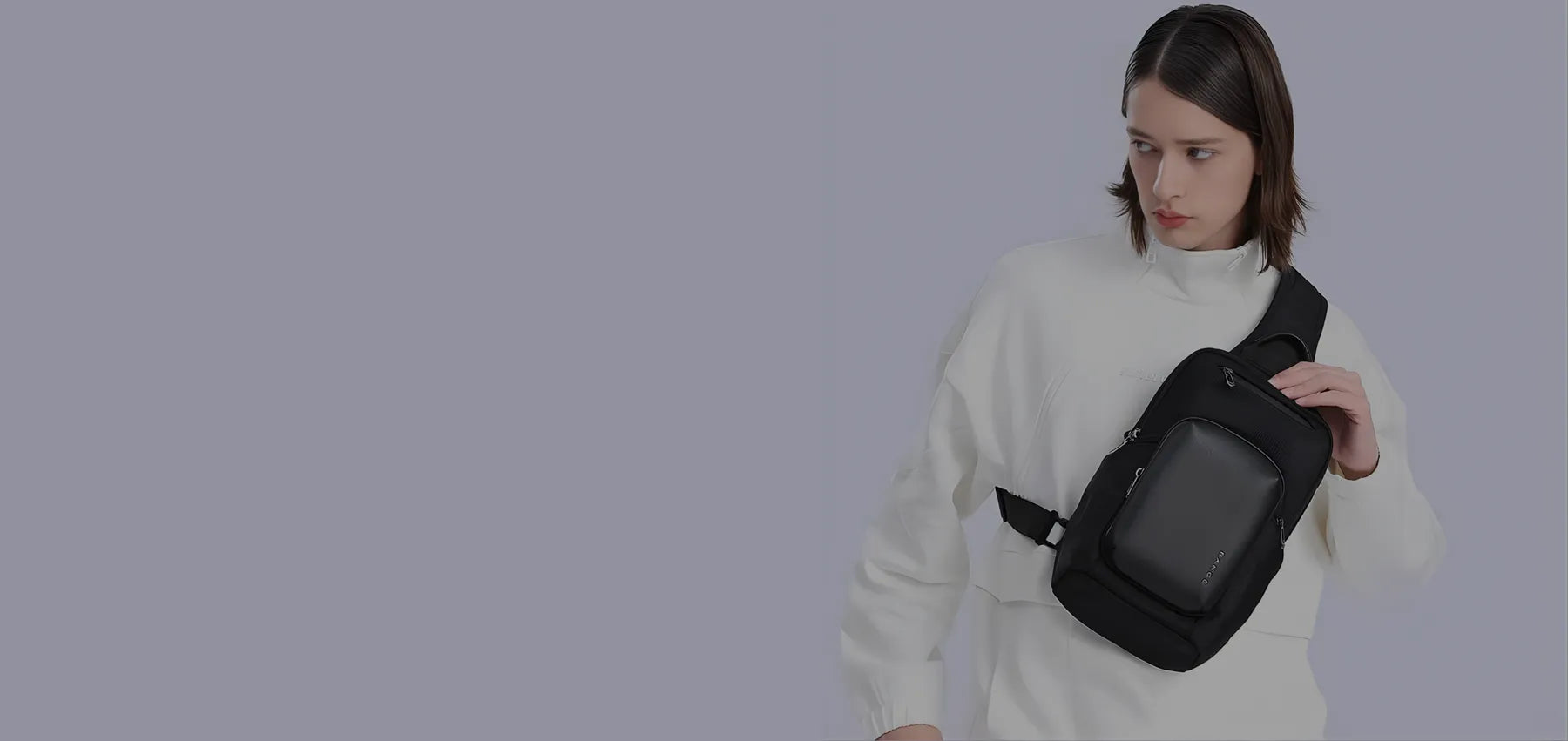 Model wearing a black BANGE sling bag across the chest against a light background